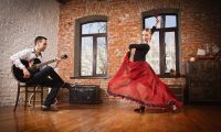 Young woman dancing flamenco and a man playing the guitar